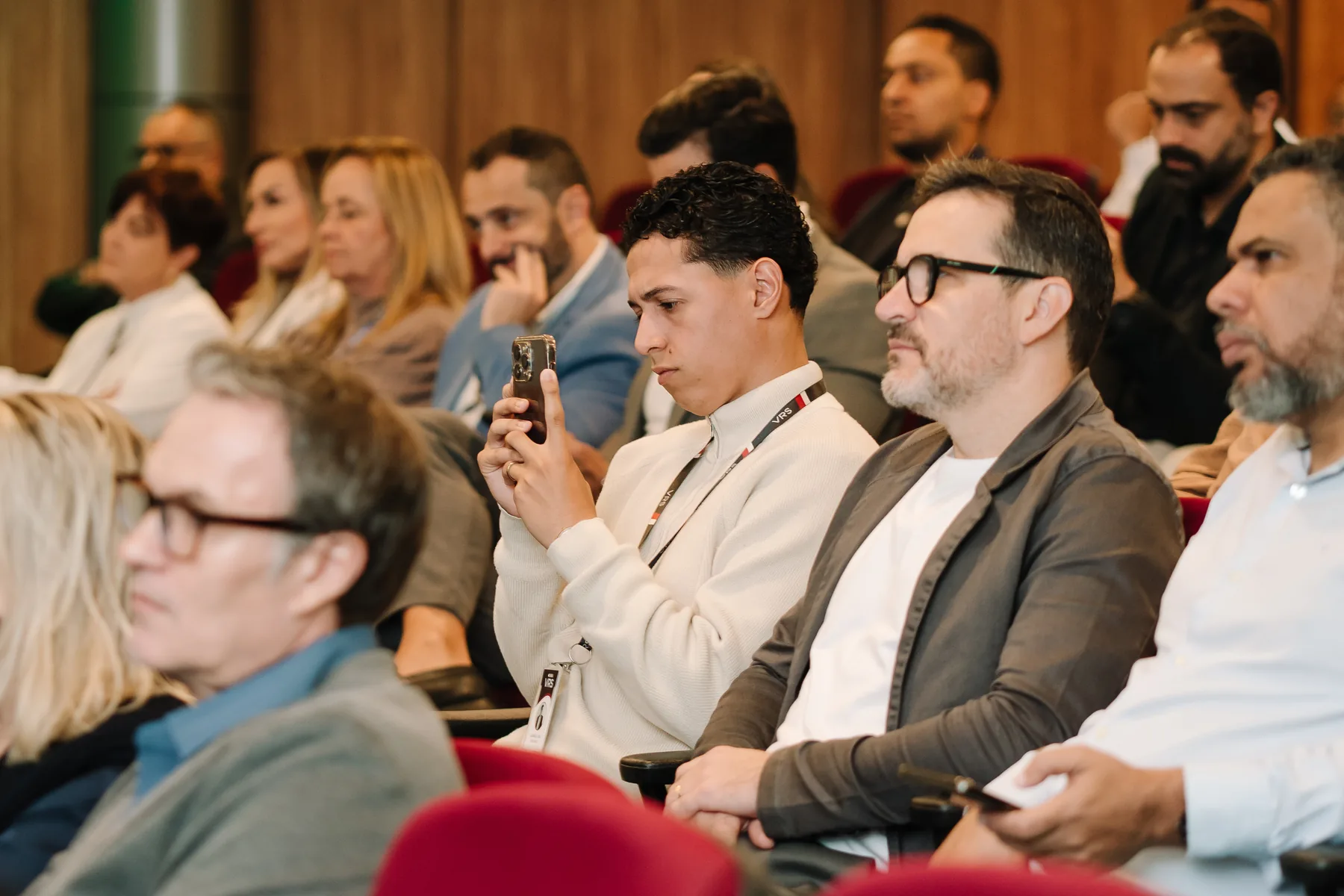 Close da plateia concentrada, anotando durante a palestra da 1ª edição